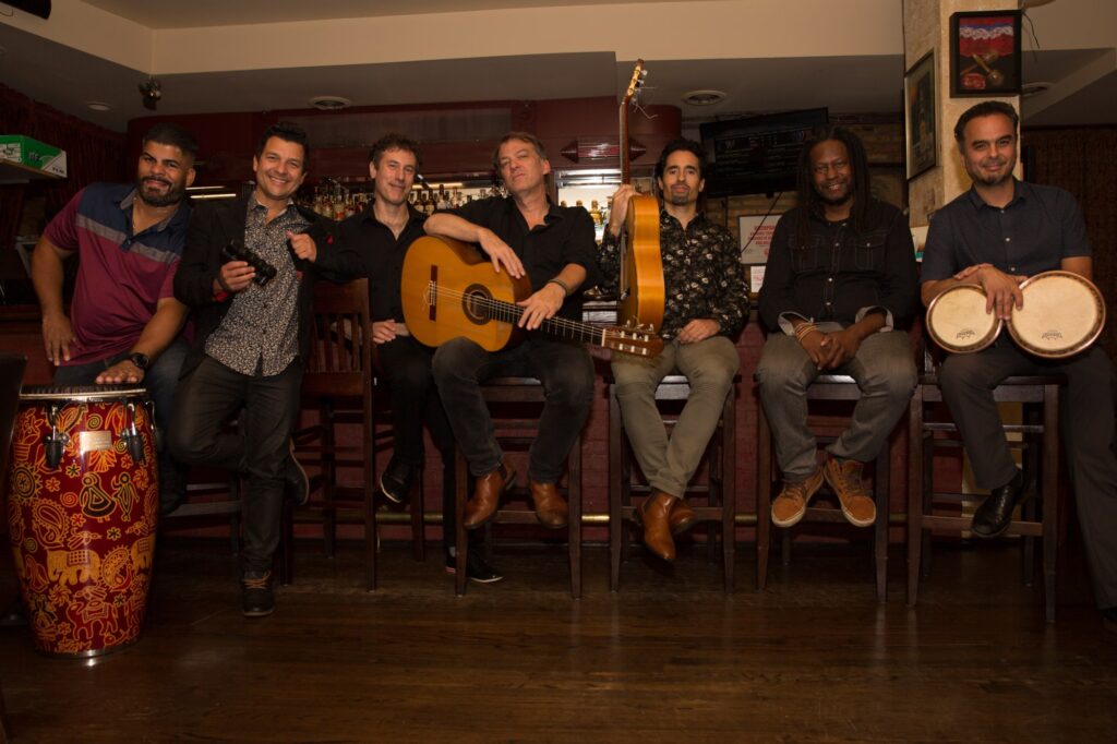 A group of men sitting in chairs holding instruments.