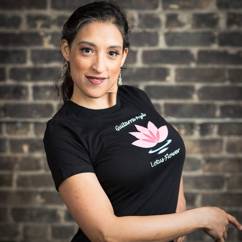 Woman in black shirt, brick wall background.