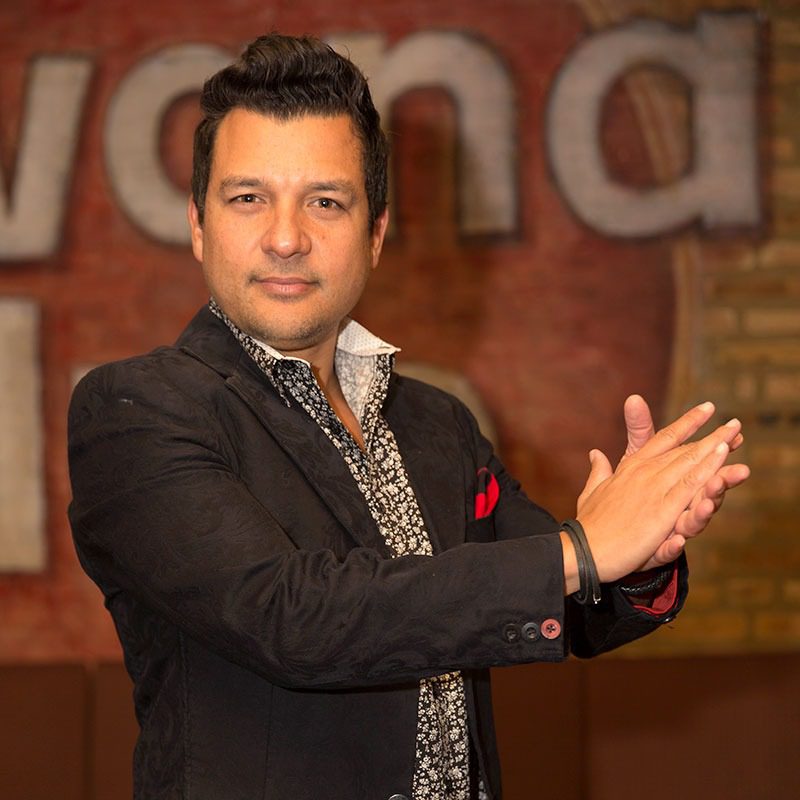 Man clapping in front of blurred background.