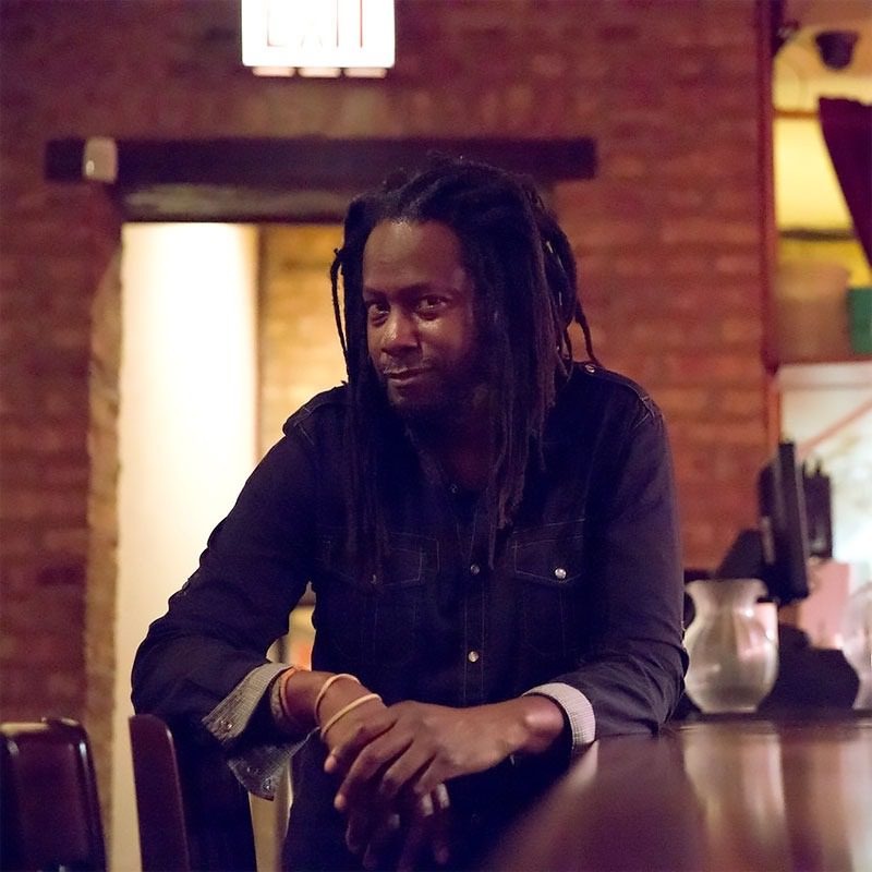 Person sitting at a dimly lit bar.