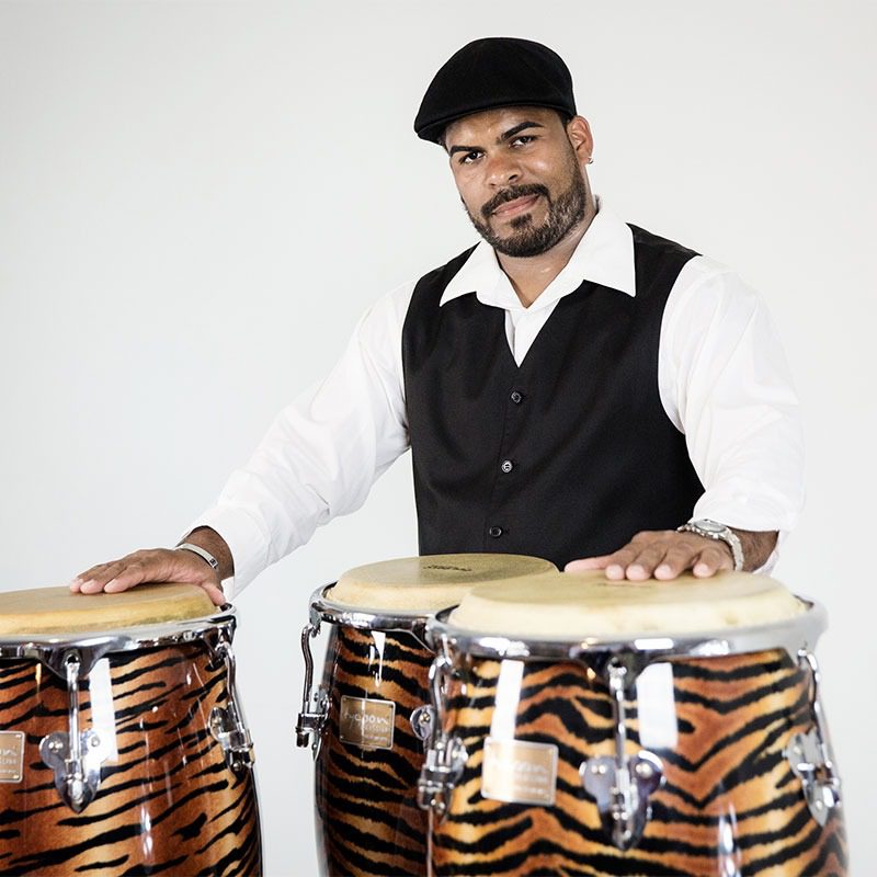Man playing tiger-striped conga drums.
